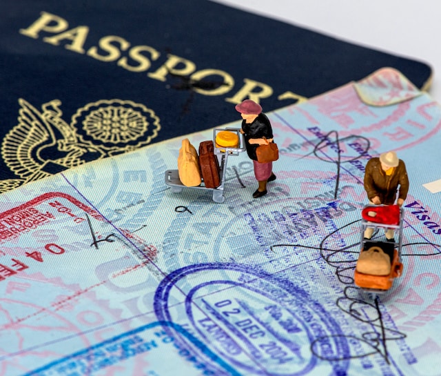 Passport open with stamps. Passport close below. Little travelers above the open passport.